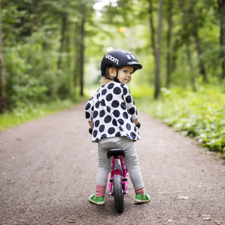Lapsi pyöräilee tiellä